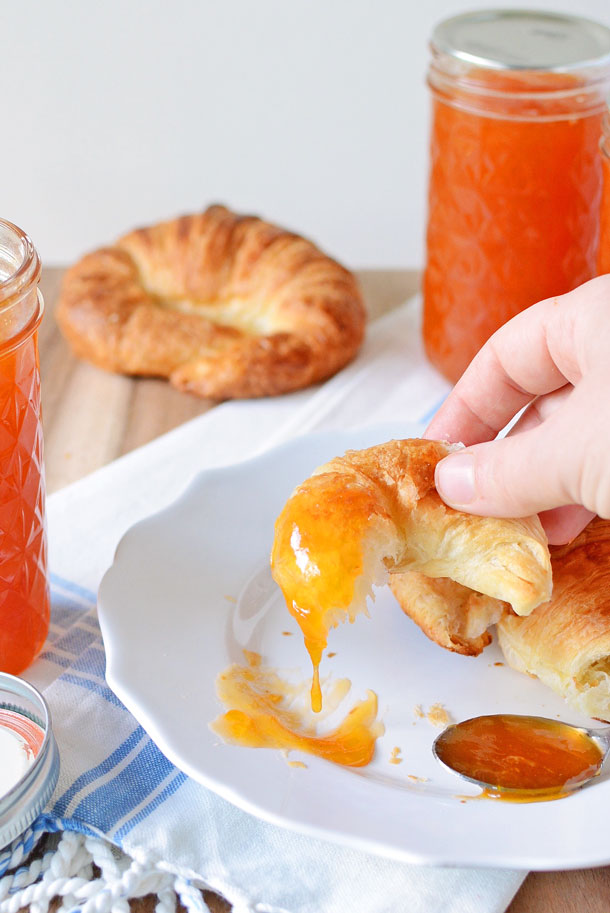 dipping a croissant in apricot jam