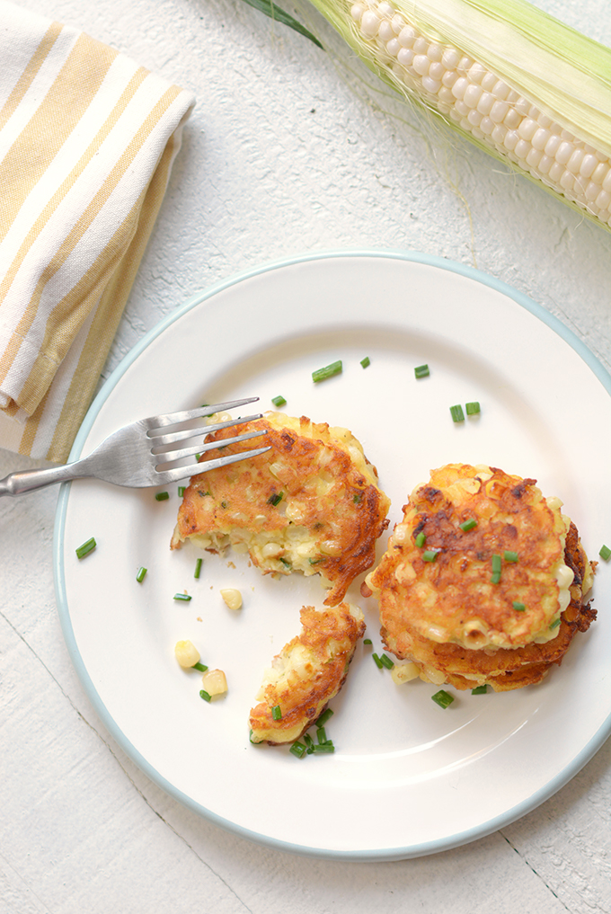 Corn fritters with chives on a plate.