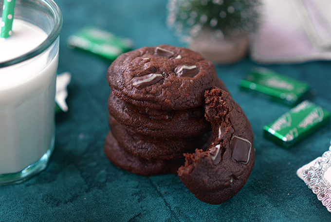 Triple-Chocolate Andes Mint Cookies in a stack with a bite taken out of one.