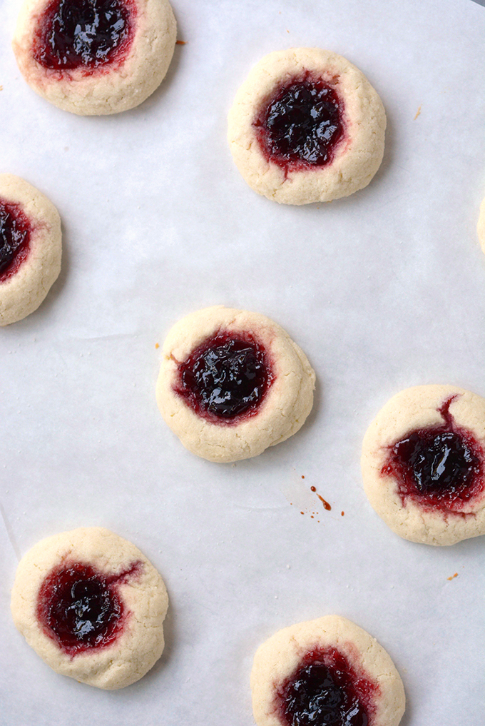 cherry almond thumbprint sugar cookies on parchment paper