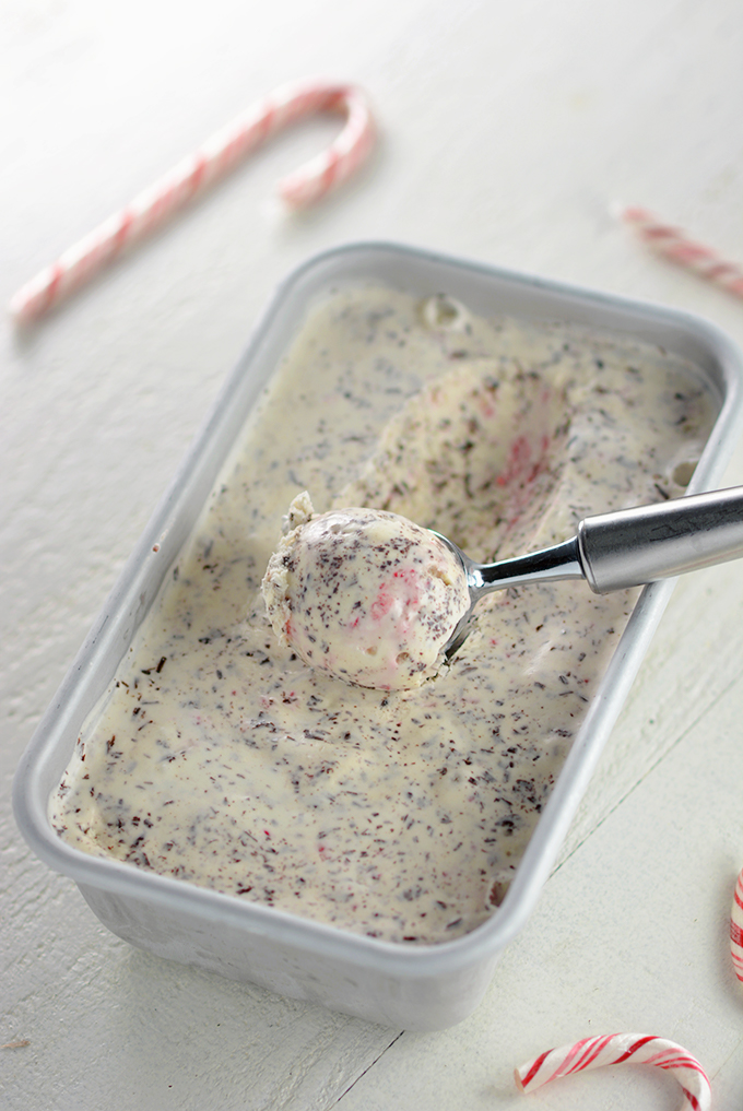 Drawing out a scoop of No-Churn Candy Cane Chocolate Chip Ice Cream from a chilled pan.