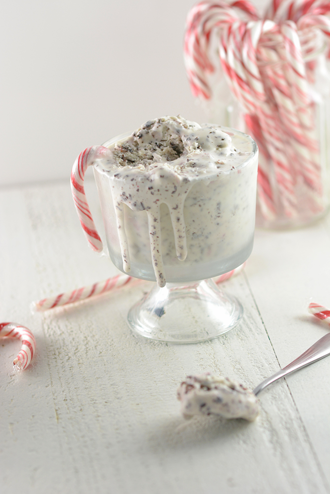 A bowl of No-Churn Candy Cane Chocolate Chip Ice Cream with drips melting down the side.
