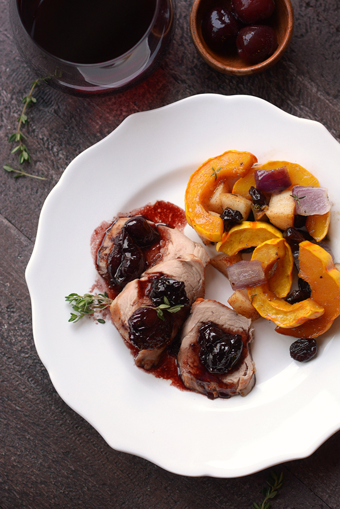 Overhead shot of pork tenderloin with cherry sauce on a plate