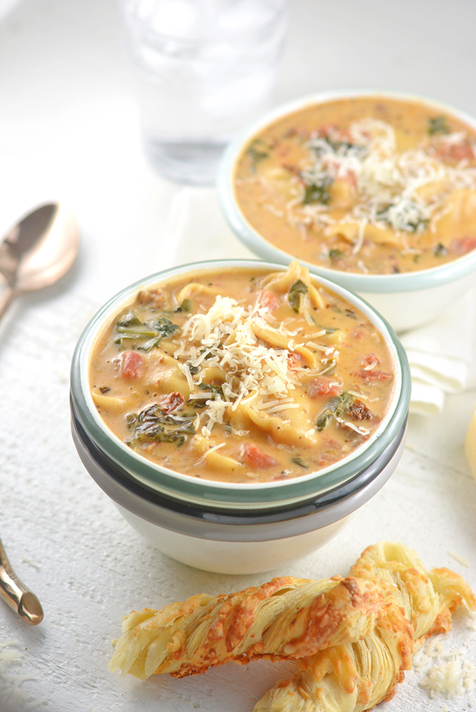 Two Bowls of Tortellini Soup Topped with Parmesan Cheese