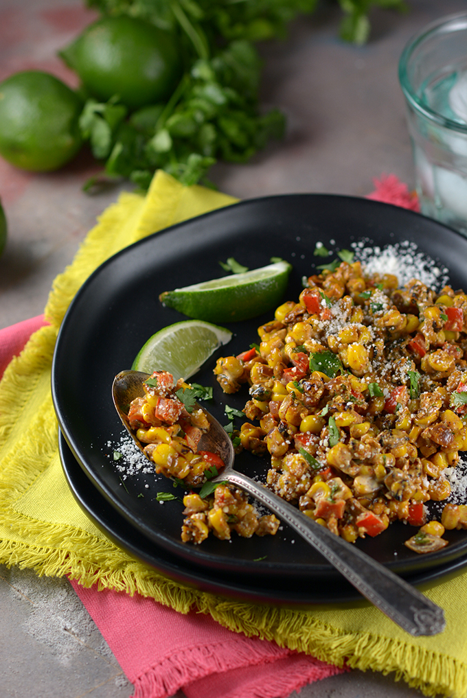 Loaded Skillet Mexican Street Corn on a plate with a spoon