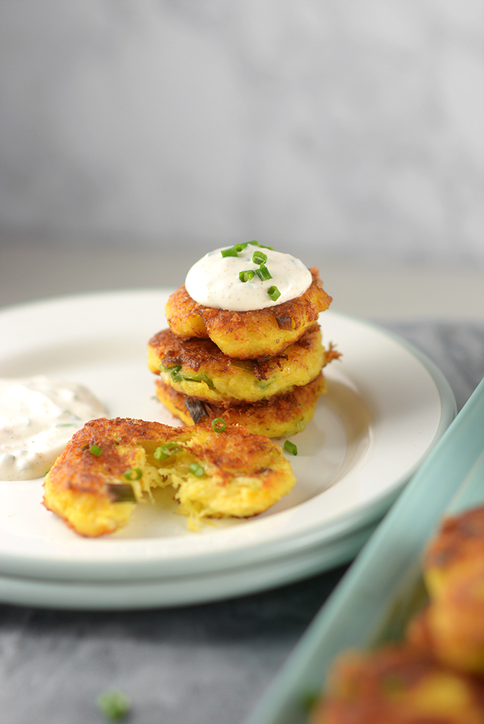 A closeup shot of spaghetti squash fritters stacked on a plate.
