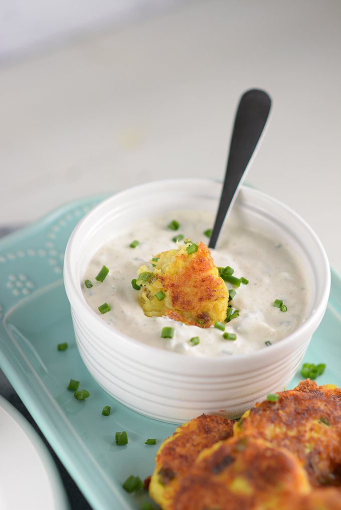 spaghettie squash fritters being dipped in sour cream